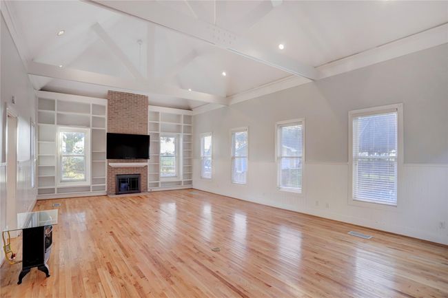 THE ENORMOUS GREAT ROOM STYLED WITH THE BEAUTIFUL SOLID WOOD FLOORS, 11'+ CATHEDRAL CEILING BOASTING HUGE WOODEN BEAMS, & RECESSED LIGHTING REVEALING AN ARRAY OF TALL 6'1/2" WINDOWS TO SHOWCASE THE OUTDOOR POOL, HOT TUB, & POOL HOUSE FOR OVERNITE GUESTS. NOTE THE GAS & WOOD FIREPLACE & FLOOR TO CEILING BUILT-INS? | Image 17