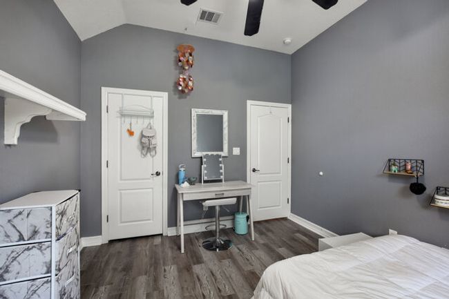 Bedroom with vaulted ceiling, wood finished floors, and a ceiling fan | Image 23