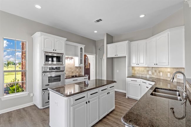 KITCHEN...Granite Tops, Dbl SS Ovens, B/I SS Microwave And Dishwasher, Smooth Cooktop, Island, Under Cabinet Lighting, W/I Pantry | Image 18