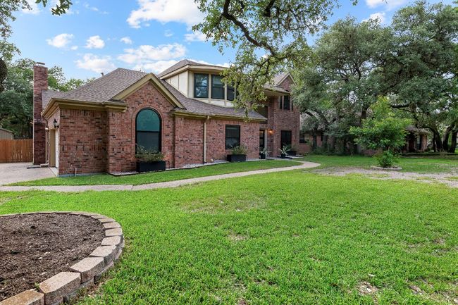 View of front of house with brick siding, a shingled roof, and a chimney | Image 4