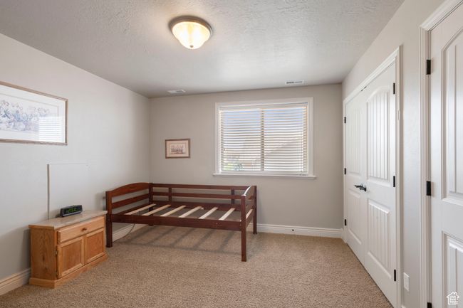 Bedroom featuring light carpet and a textured ceiling | Image 22