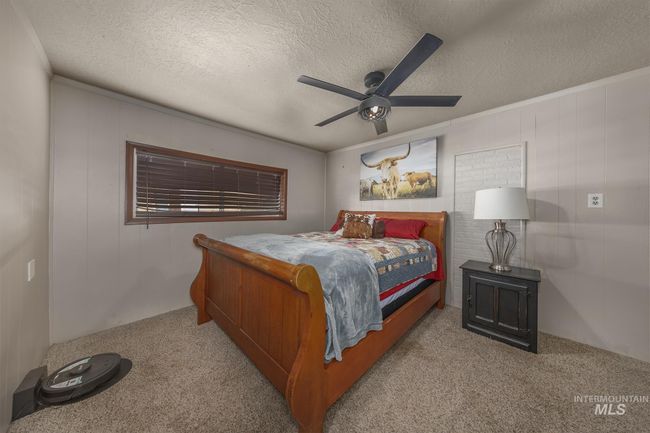 Bedroom featuring carpet floors, a textured ceiling, and ceiling fan | Image 15