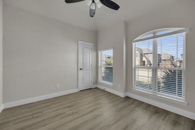 Office or bedroom with walk-in closet. Light wood-type flooring, walk-in closet, and ceiling fan | Image 12