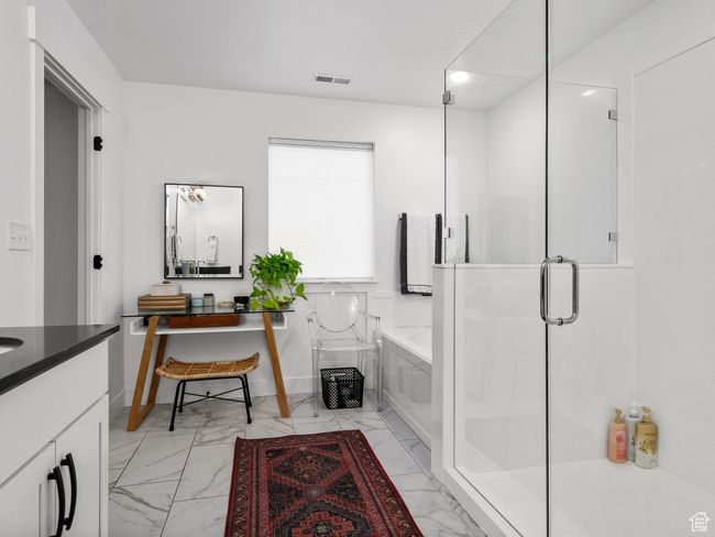 Bathroom featuring marble finish flooring, a garden tub, vanity, a stall shower, and recessed lighting | Image 32