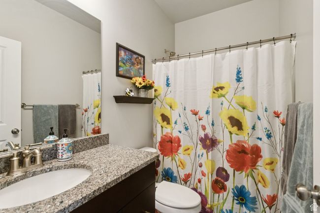 Bathroom featuring vanity and curtained shower | Image 12
