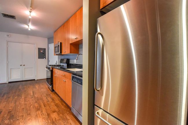 Another angle of the kitchen featuring a sleek stainless steel refrigerator, perfectly complementing the modern design. | Image 22