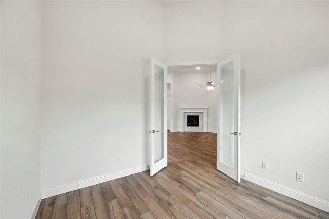 Unfurnished room with tile floors, french doors, a fireplace, and a ceiling fan | Image 16