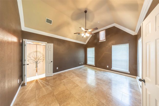 Empty room featuring ceiling fan, lofted ceiling, and crown molding | Image 19