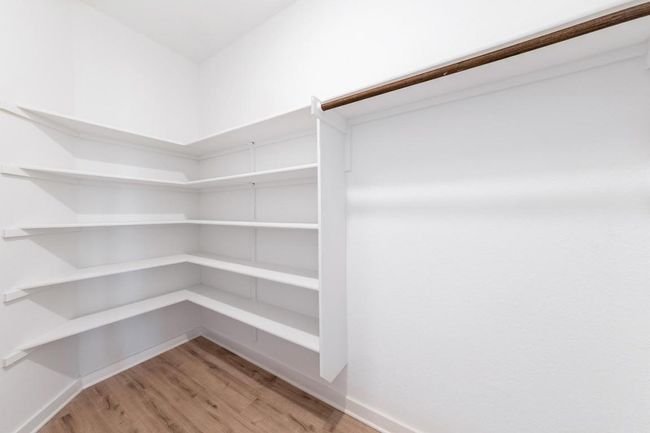 Walk in closet with light wood-style floors | Image 26