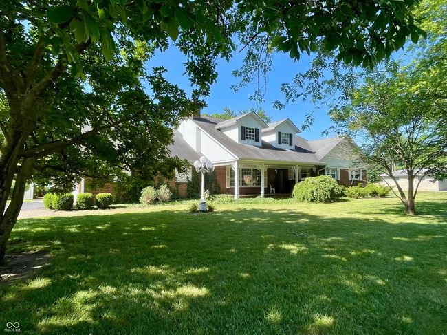 New England style home with a front lawn and brick | Image 7