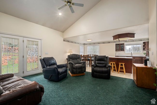 Living room with dark carpet, recessed lighting, ceiling fan, and high vaulted ceiling | Image 16