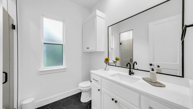 Bathroom featuring toilet, vanity, tile patterned flooring, and a shower stall | Image 10