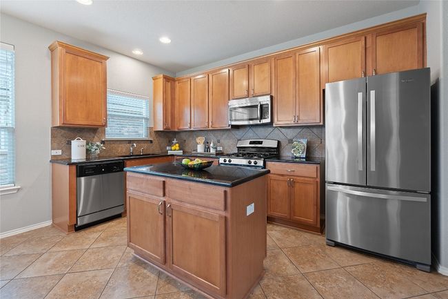 Kitchen with appliances with stainless steel finishes, backsplash, a center island, and recessed lighting | Image 15
