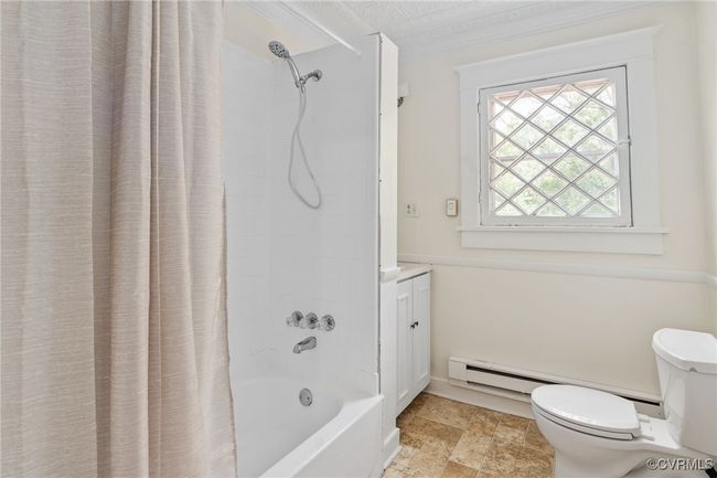 Bathroom with toilet, shower / bathtub combination with curtain, vanity, and a baseboard radiator | Image 29