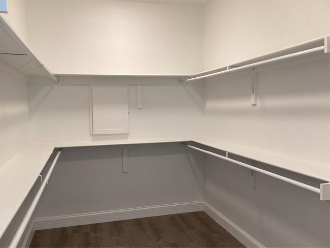 Spacious closet with dark wood-style floors | Image 22