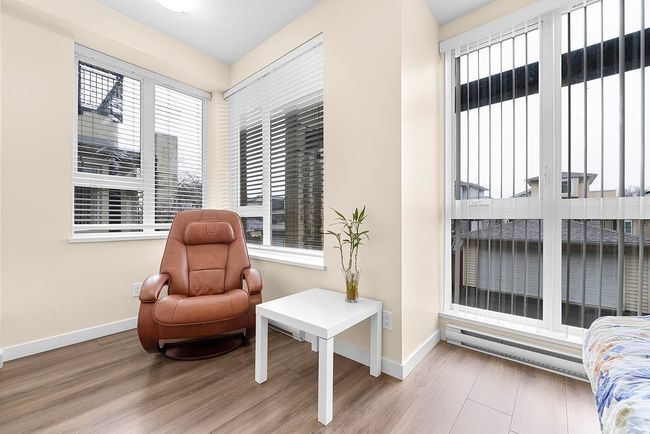 Living area featuring baseboards, baseboard heating, and wood finished floors | Image 15