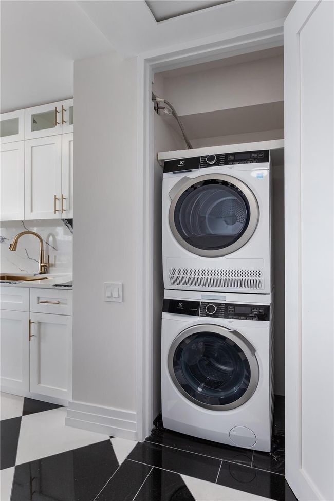 Laundry room with stacked washer / dryer and tile patterned flooring | Image 18