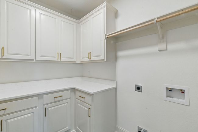 Laundry area with electric dryer hookup, washer hookup, cabinet space, and baseboards | Image 25