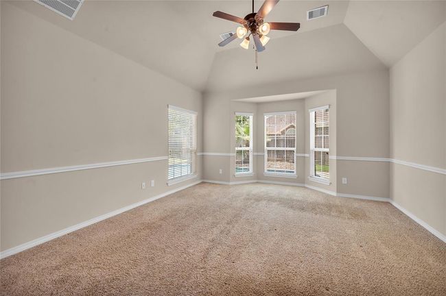 Exquisite owner's retreat featuring vaulted ceilings, chair rail molding, and a bay window overlooking a serene backyard oasis. | Image 21