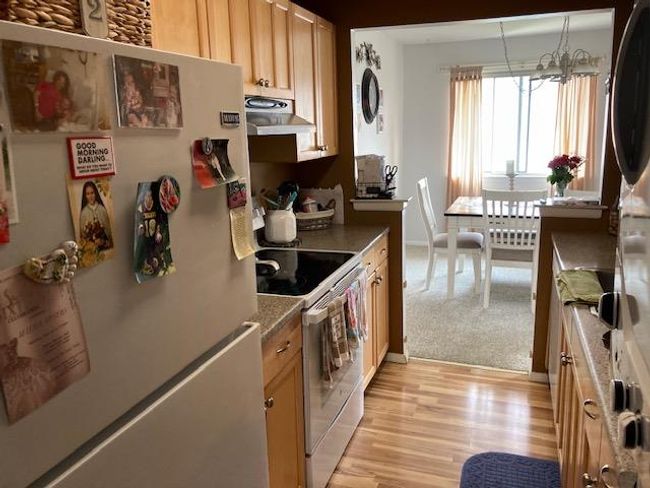 Kitchen featuring freestanding refrigerator, electric range, ventilation hood, and light wood-style floors | Image 4