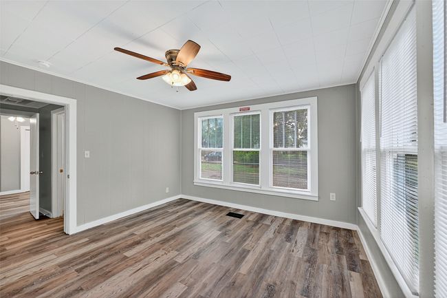 Unfurnished bedroom with ornamental molding, wood finished floors, and ceiling fan | Image 15