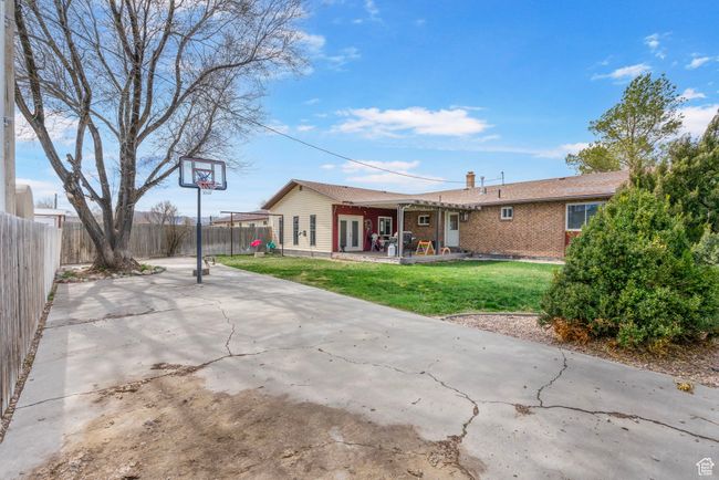 Rear view of house with a patio, a chimney, a yard, brick siding, and fence private yard | Image 38