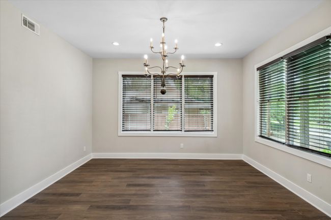Unfurnished room featuring a chandelier, plenty of natural light, baseboards, dark wood-style flooring, and recessed lighting | Image 4
