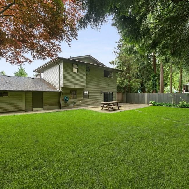 Rear view of property with central AC unit, a patio area, fence, and a lawn | Image 8