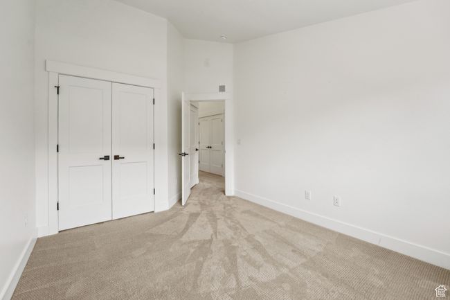 Unfurnished bedroom featuring a closet, baseboards, and light colored carpet | Image 40