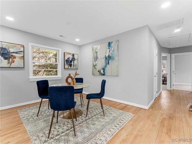 Dining area with attic access, light wood-type flooring, visible vents, and baseboards | Image 31