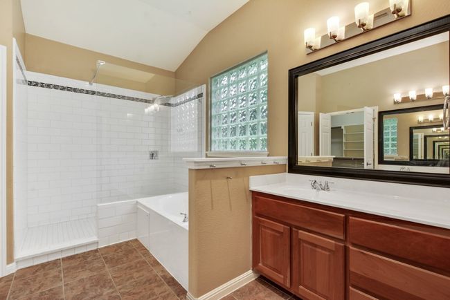 The spacious primary suite is a true retreat, complete with a luxurious bath featuring dual vanities, a walk-in shower, a soaking tub, and an oversized walk-in closet. | Image 23