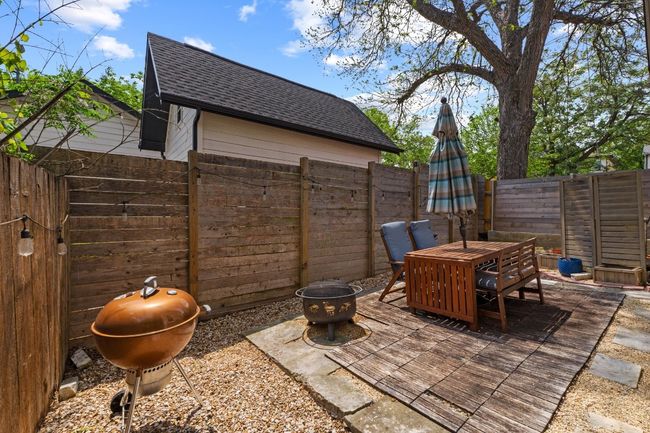 View of patio featuring an outdoor fire pit, a fenced backyard, and area for grilling | Image 26