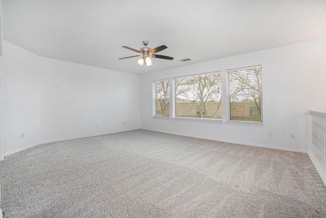 Empty room with baseboards, carpet floors, ceiling fan, and windows. | Image 17