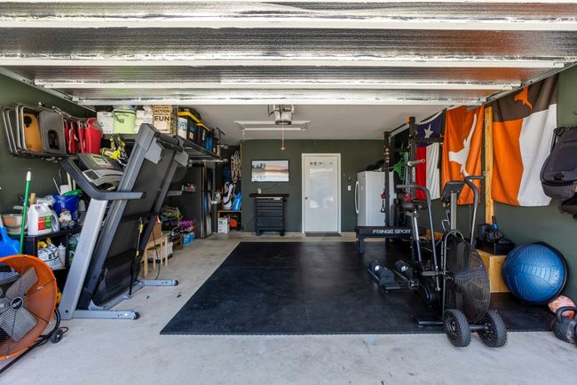 Garage featuring a garage door opener and freestanding refrigerator | Image 27
