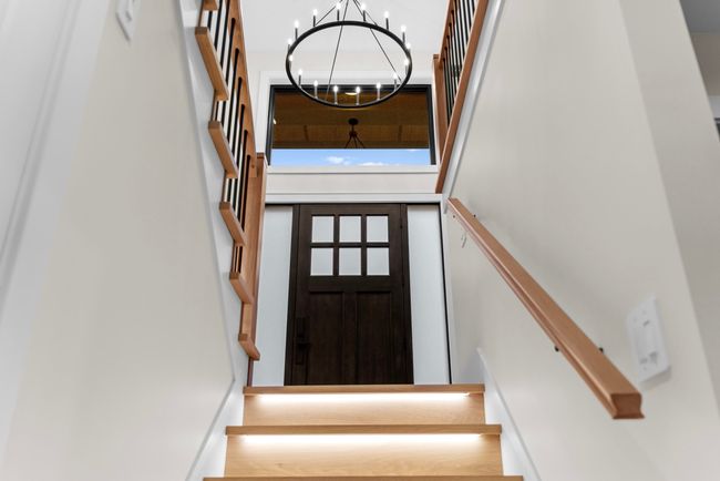 Stairs featuring a chandelier and a towering ceiling | Image 30