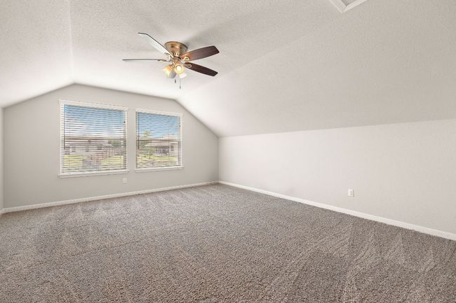 Bonus room featuring lofted ceiling, a ceiling fan, carpet floors, and baseboards | Image 24