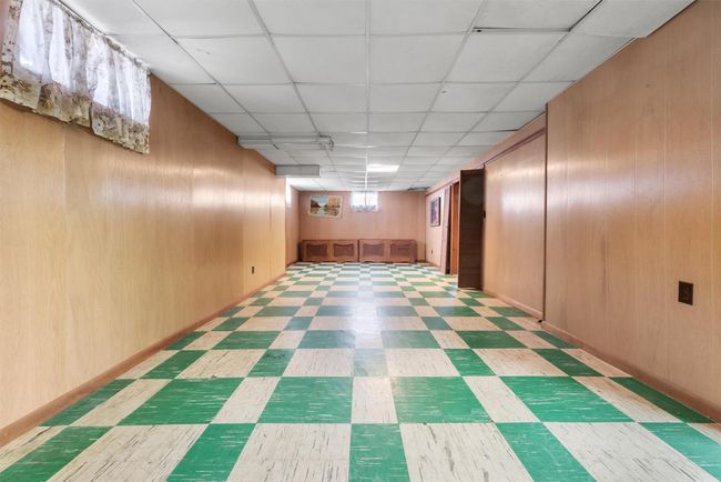 Finished below grade area with a paneled ceiling, wooden walls, and tile patterned floors | Image 27