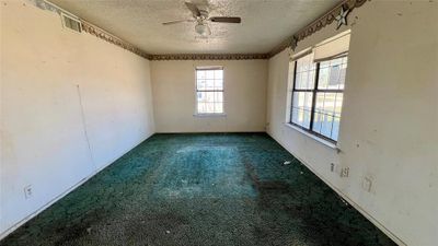 Carpeted spare room with ceiling fan and a textured ceiling | Image 2