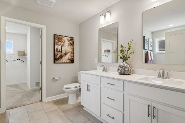 (Photo of model home, actual features may vary) An extension of the owner's suite, this private and spacious bath contains a double-vanity, a separate shower, and a soaking tub. | Image 10