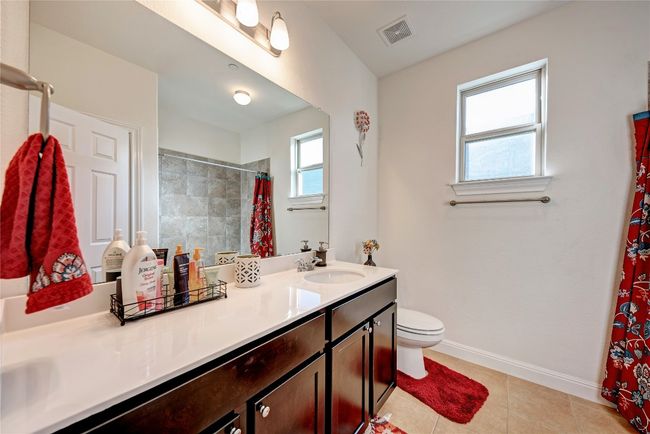 Bathroom with vanity, toilet, baseboards, a shower with shower curtain, and tile patterned flooring | Image 15