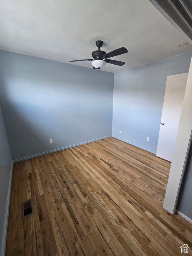 Empty room with a ceiling fan and hardwood / wood-style flooring | Image 12
