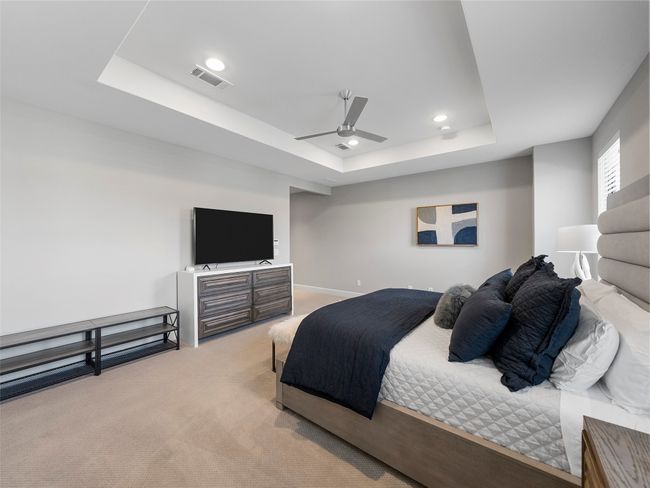 Bedroom featuring a raised ceiling, light carpet, recessed lighting, and ceiling fan | Image 23