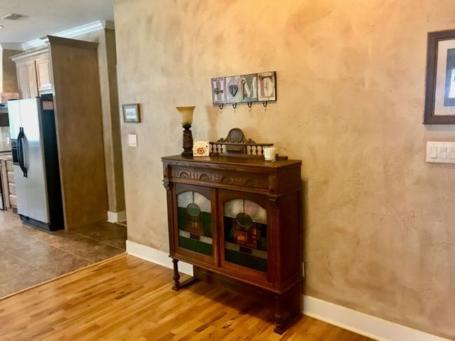 Foyer featuring wood finished floors, baseboards, and crown molding. Beautiful faux finish on walls throughout | Image 7