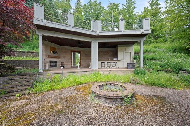 Back of house featuring an outdoor fire pit | Image 47
