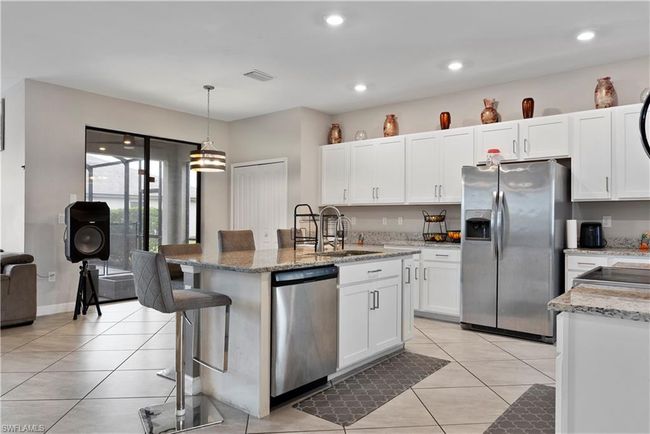 Kitchen with white cabinetry, visible vents, light tile patterned floors, and appliances with stainless steel finishes | Image 11
