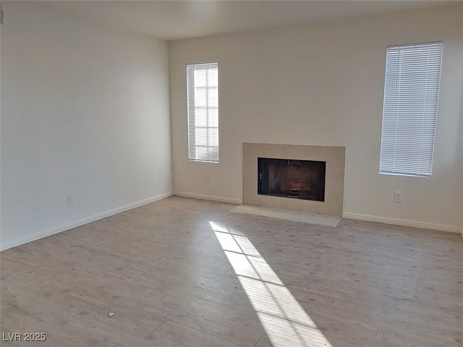 Unfurnished living room with light hardwood / wood-style flooring and a tiled fireplace | Image 4