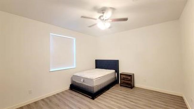 Bedroom with wood finished floors and ceiling fan | Image 13