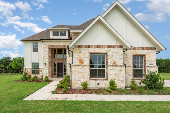 View of front of house with stone siding, a front lawn, and roof with shingles | Image 4