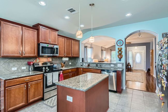 Kitchen with arched walkways, visible vents, appliances with stainless steel finishes, and a sink | Image 10
