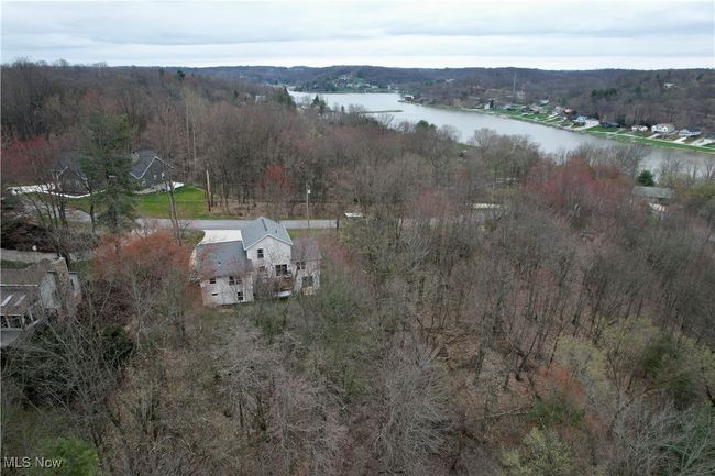 Aerial overview of property's location with a nearby body of water and a forest | Image 5